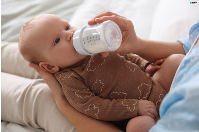 A baby being gently fed to stay hydrated as part of a baby skin care for summers routine.