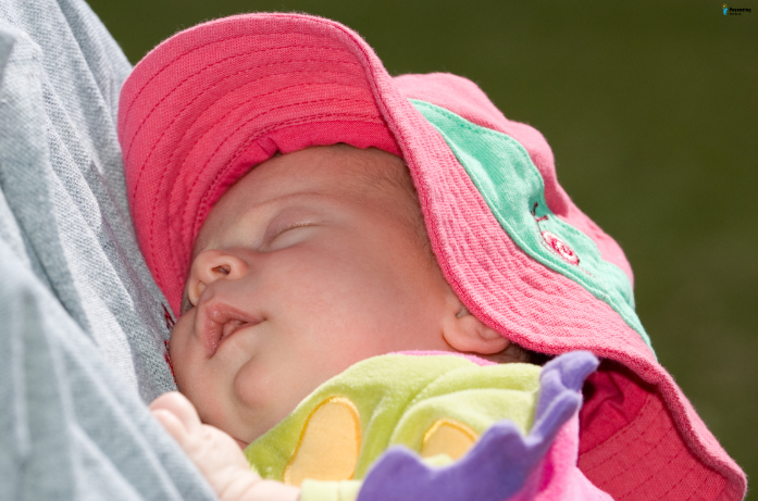 Baby protected from the sun with a wide-brimmed hat as part of essential baby skin care for summers.